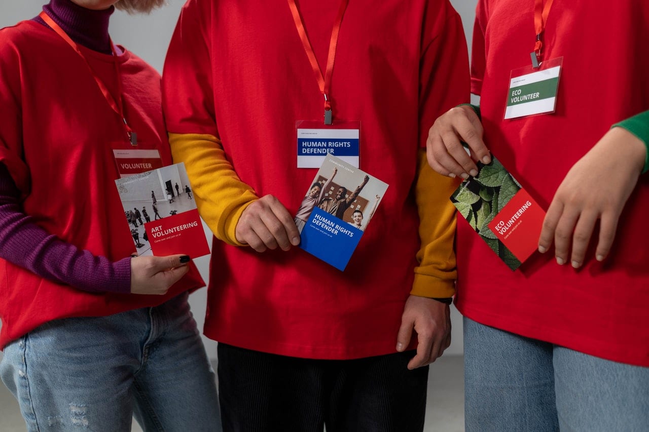 Image shows a group of three volunteers working wearing red t-shirts., illustrating the concept of non-profit organisations