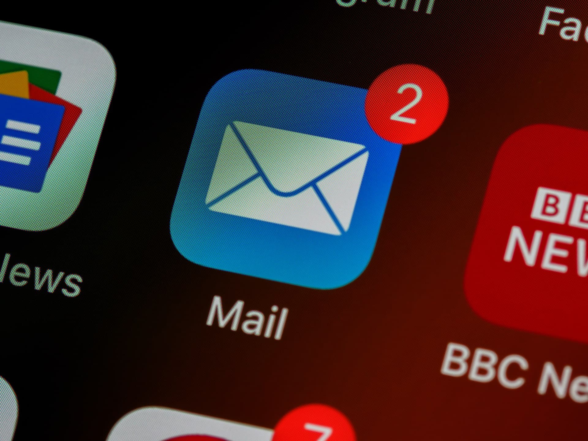 The image shows a blue-and-white logo of the Mail app to illustrate the concept of mass mailing.